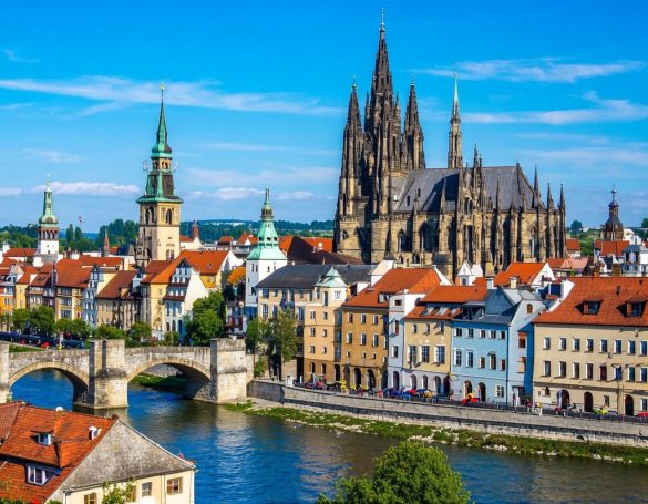 Prager Burg vor der Moldau mit bunten Dächern und dem Karlsbrücke im Vordergrund.